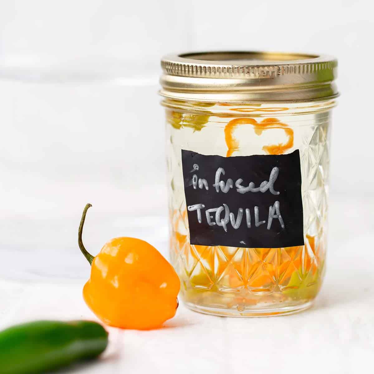 Habanero Infused Tequila adds the perfect little spicy punch to all your tequila cocktails! infused tequila | tequila | how to infuse tequila | how to infuse tequila with habanero | tequila infused with habanero jalapeno | mango habanero margarita