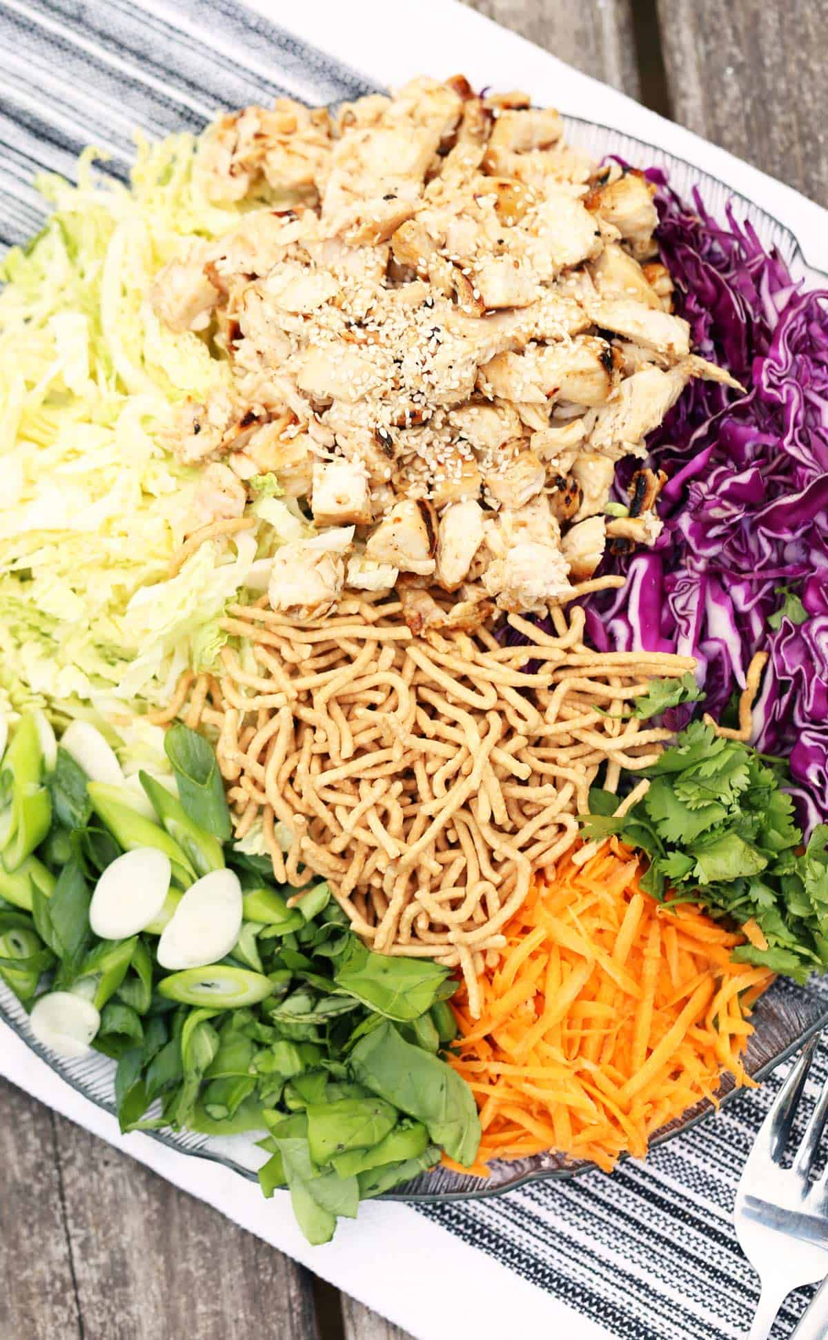 Packed full of flavor this easy make ahead Sesame Chicken Salad is a mix of crisp vegetables, grilled chicken, crunchy noodles and fresh herbs.