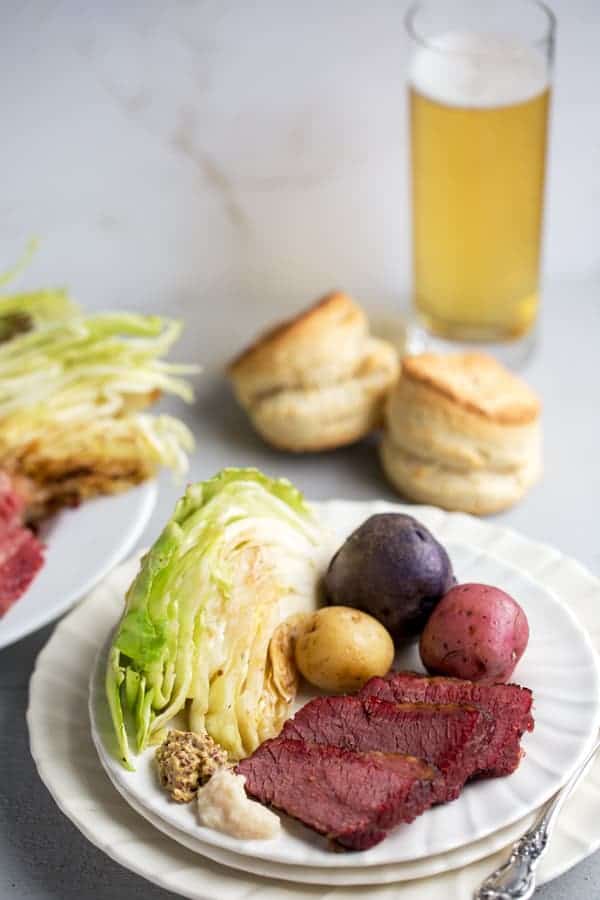 Baked Corned Beef and Cabbage braised until tender in the oven and served with tender but fresh blistered cabbage and tri color petite potatoes