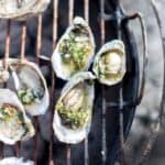 Grilled oysters rockefeller on the half shell still on the grill.
