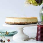 Churro cheesecake made like a classic cheesecake with a cinnamon crunch crust served with blackberry sauce on the side.