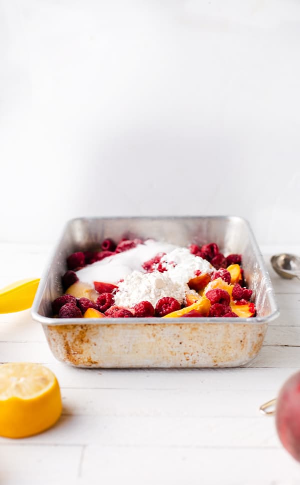 Vegan Raspberry Peach Cobbler is an easy dessert recipe highlighting peaches and raspberries with a vegan version of my favorite fluffy cobbler topping!  Peach cobbler recipe | vegan peach recipes | raspberry cobbler | peach melba cobbler | raspberry peach dairy free isa does it 