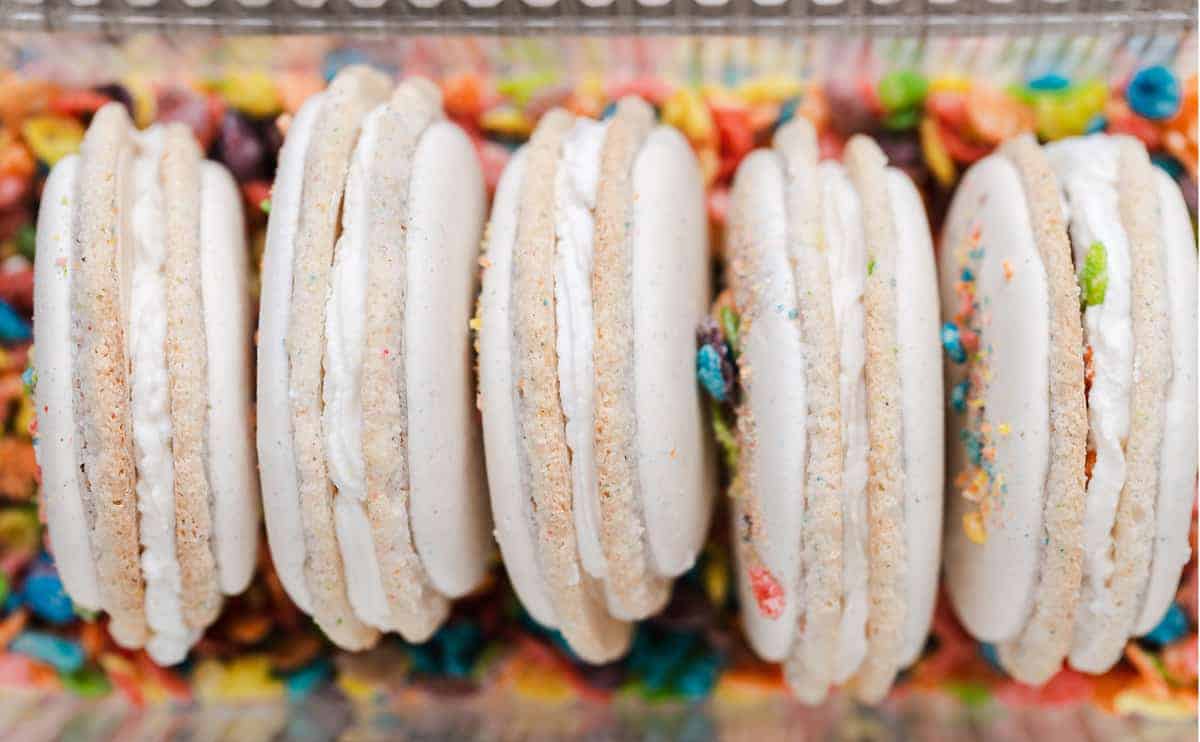 Fruity PEBBLES™ Cereal Milk Macarons are a perfect classic vanilla macaron shell with colorful flecks of tropical fruit flavored cereal and finished with a cereal milk cream macaron filling. Fruity PEBBLES™ Cereal milk macarons recipe | macarons filling ingredients | Fruity PEBBLES™ cookies | gluten-free baking #recipe #glutenfree #cookies #ad 