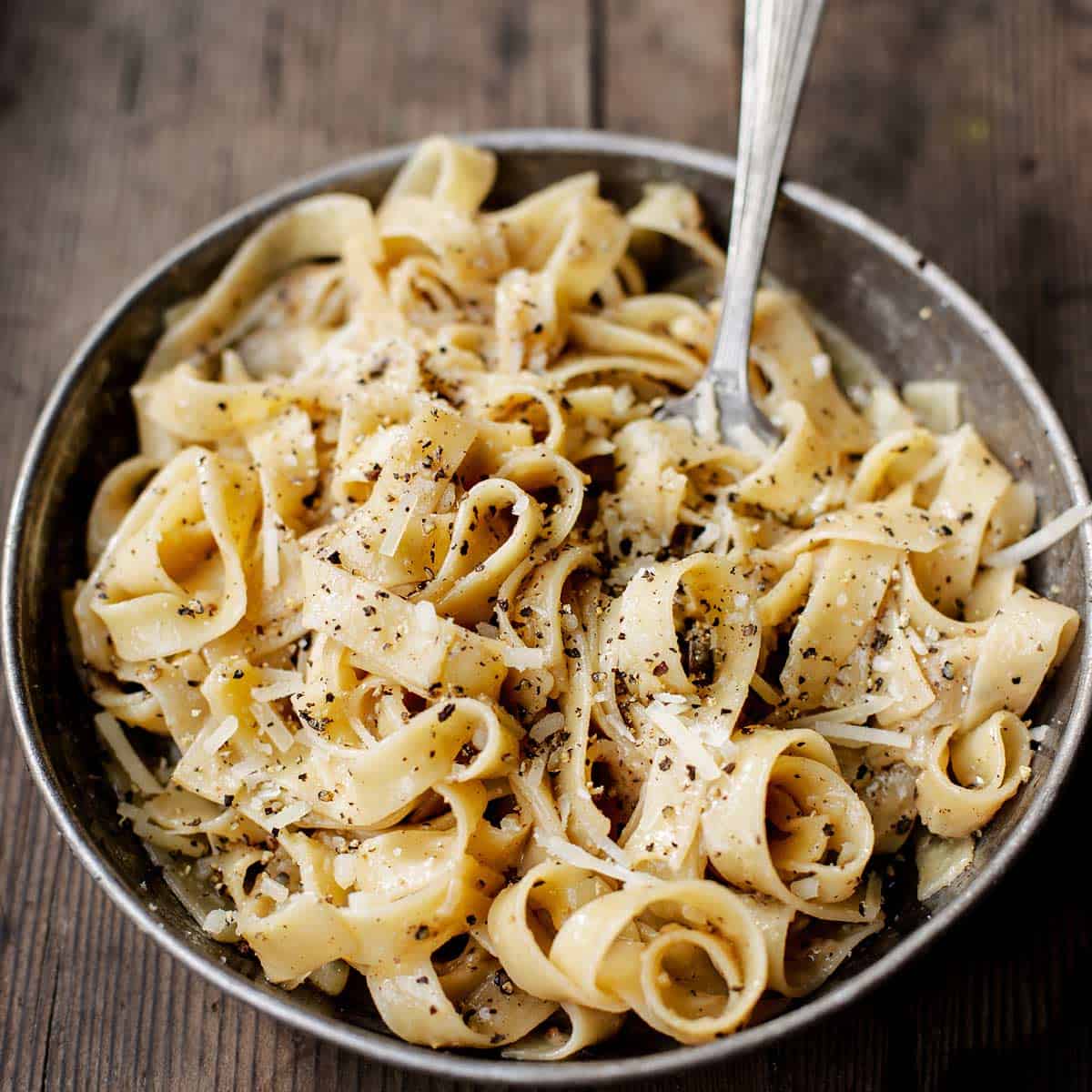 simple black pepper pasta on aged wood board