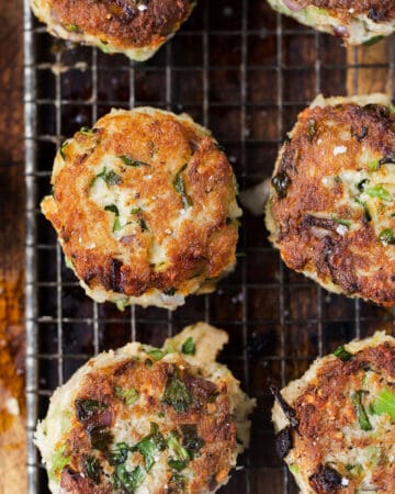 Close up of pan fried crab cakes recipe with scallions and red onions