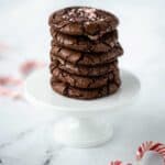 Stack of chewy Chocolate Peppermint Crinkle Cookies with candy canes