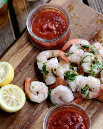 shrimp cocktail platter with cocktail sauce and beer
