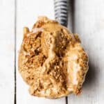 A scoop of smooth, velvety frozen dalgona ice cream on a vintage ice cream scoop.