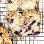 Slices of soft loaf bread studded with pockets of blueberries and topped with toasted oat crumble.