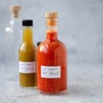 Green hot sauce and red homemade hot sauce in bottles.