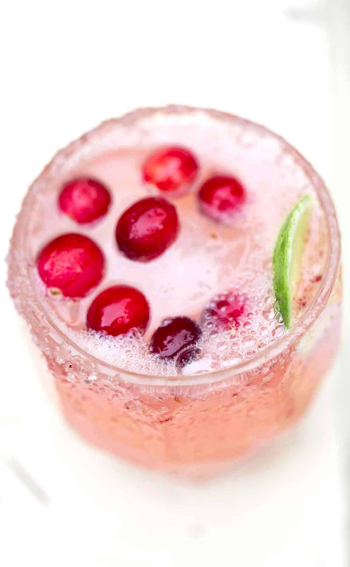 A fresh cocktail with cranberries and lime.