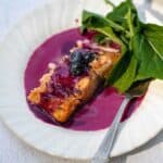 Blueberry beurre blanc salmon with savory blueberry and greens.