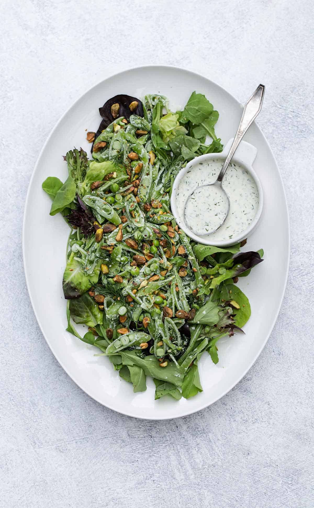 Salad with pistachios on a white platter