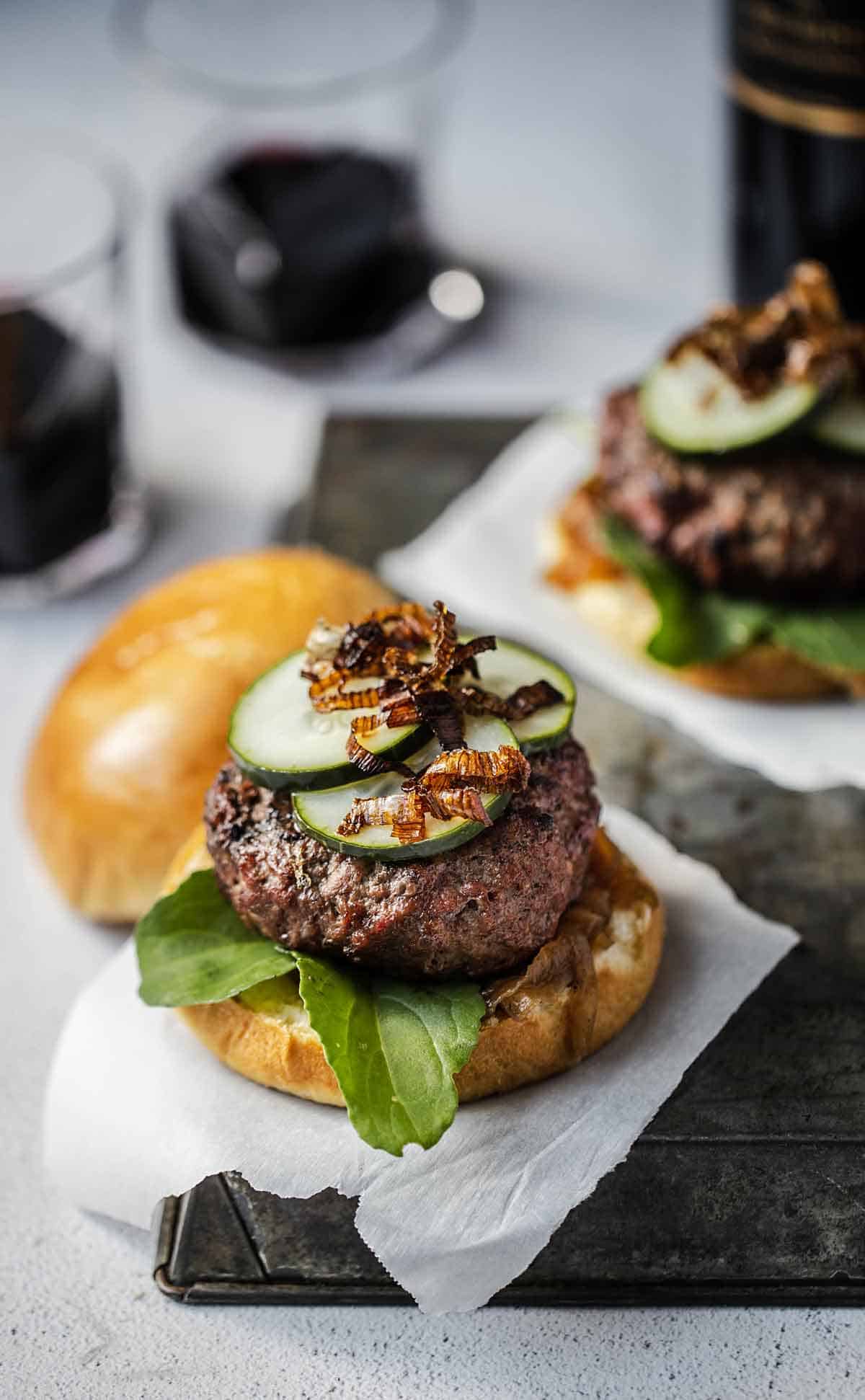 Smoked gouda burgers served with red wine and assorted burger toppings.